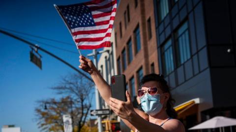 A woman waves an American flag during a celebration in Astoria