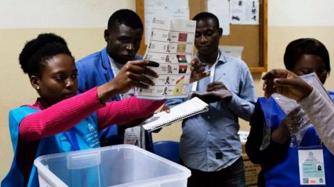 A polling station official shows a ballot during the counting of votes at the end of the general election in Luanda