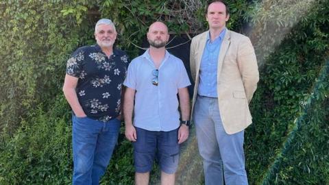 Dr Dan Poulter (far right) standing alongside former Apostle clients Robert Catling and Rueben Ward