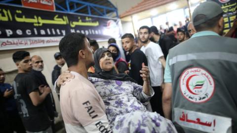 An elderly woman is carried into the Kuwaiti Specialist Hospital in Rafah, in the southern Gaza Strip (8 May 2024)
