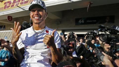 Lewis Hamilton holds up six fingers after winning his sixth driver's title