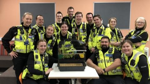 Northamptonshire Police officers pose with Craig the budgie