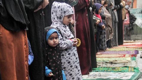 Palestinian children perform Eid prayers in the rain in northern Gaza on 10 April