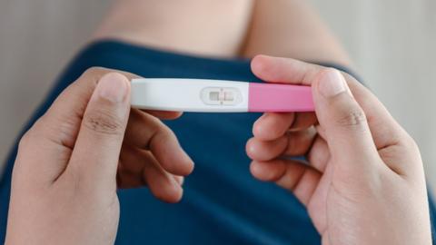 Stock image of hands holding a pregnancy test