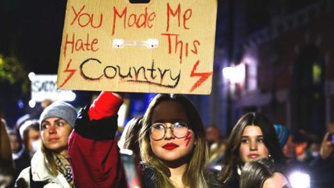 A protesters holds up a placard at a rally against Poland's restrictive abortions laws