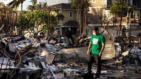 A volunteer makes damage assessment of charred apartment complex in the aftermath of a wildfire in Lahaina, western Maui, Hawaii on August 12, 2023