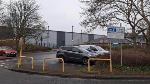 Several cars parked at Woodley Road car park with a grey industrial building behind. A Southampton City Council sign says '2 hours max stay'