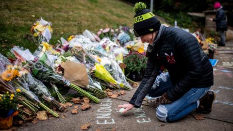 A girl lays flowers at the scene of the shooting in Pittsburgh