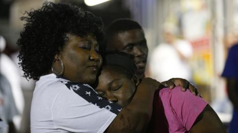 Mourners embrace during a vigil