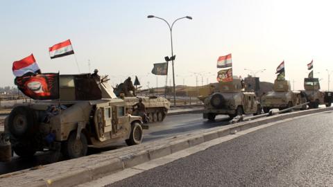 A convoy of Iraqi military trucks flying religious Shiite flags and Iraqi national flag as they advance into the central of Kirkuk city, northern Iraq