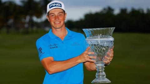 Viktor Hovland smiles as he holds up the Puerto Rico Open trophy