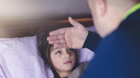 Father putting his hand on child's forehead