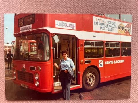 Gwen Walton standing in front of a red bus