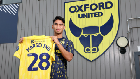 New Oxford United signing Marselino Ferdinan holding up United's home shirt