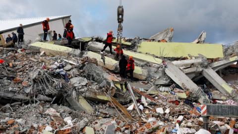 Rescue workers on a pile of rubble