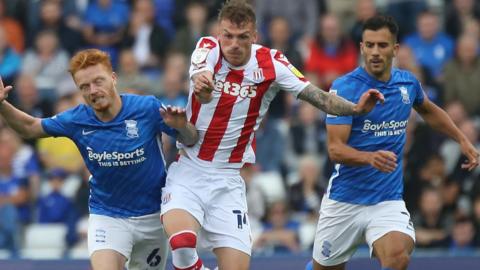 Stoke City's Josh Tymon and Birmingham City's Ryan Woods challenge for the ball