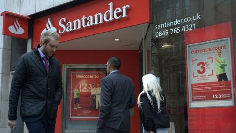 People walk past a Santander branch