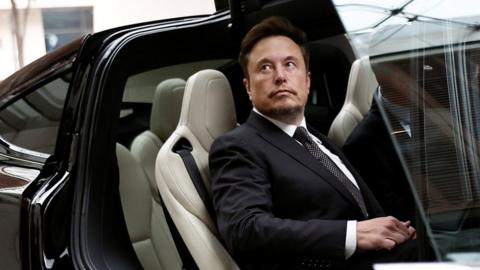 Elon Musk gets in a Tesla car as he leaves a hotel in Beijing, China on 31 May.