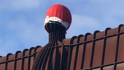 Close-up of the Angel of the North with a Santa hat