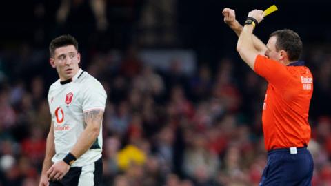 Wales wing Josh Adams is shown a yellow card by referee Matthew Carley that was upgraded to red
