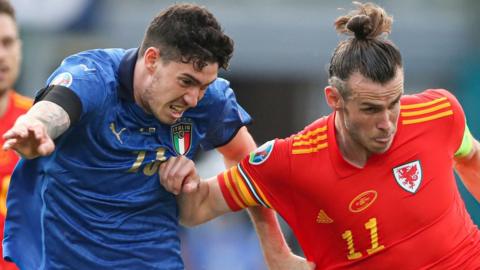 Alessandro Bastoni of Italy challenges Gareth Bale
