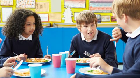 Stock image of schoolchildren eating lunch