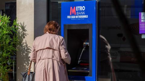 Woman using Metro Bank ATM