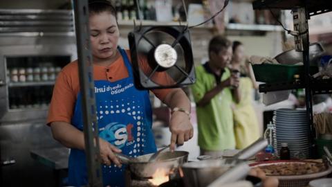 A woman works in restaurant kitchen in Thailand