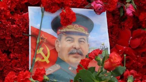 A picture of Joseph Stalin surrounded by red carnations