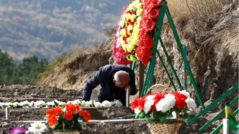A man mourns at the grave of a fallen soldier, who was killed during the military conflict over the breakaway region of Nagorno-Karabakh, in Stepanakert 14 October, 2020.
