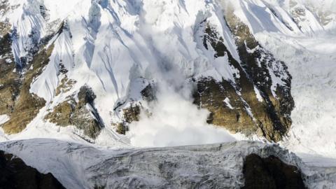 An ice avalanche is shooting down an icy rock slope