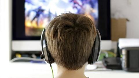 A boy playing a video game with headphones on