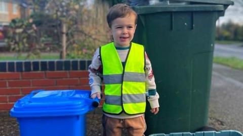 Samuel helps his dad put the bins out the night before