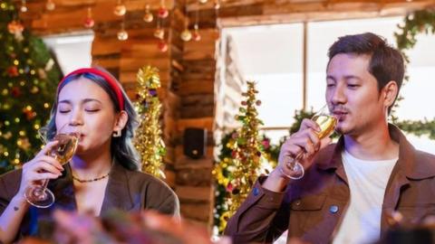 People enjoying a glass of wine at a Christmas party