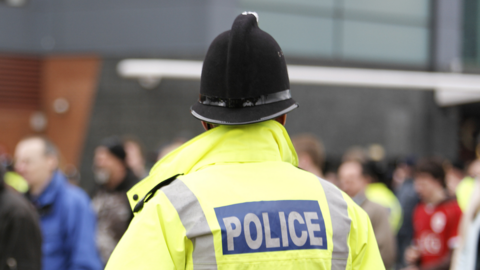 Police officer from the back, in hi-vis jacket