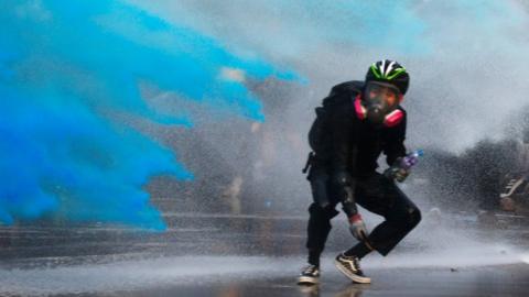 An anti-government protester is sprayed with blue-coloured water in Hong Kong - 15 September 2019