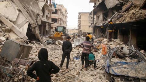 Rescue workers clear debris from the site of an air strike in Ariha, in Idlib province, Syria (30 January 2020)