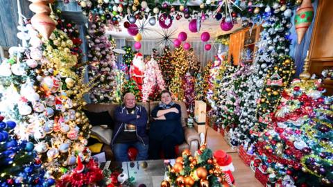 Susanne and Thomas Jeromin, the official world record holders with their 555 decorated Christmas trees in one home, pose for a photo in their living room in Rinteln, west of Hanover, Germany,