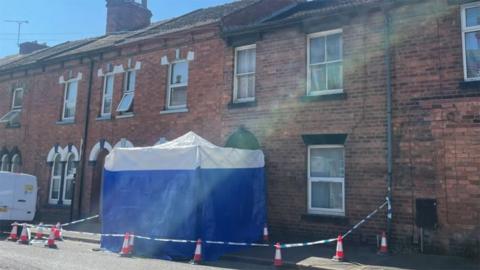 A blue police forensic tent on the pavement outside the terrace house in Lincoln where John Connolly's body was found