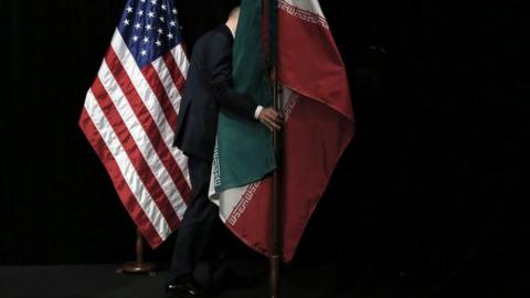 Member of staff removes the Iranian flag from the stage after a group picture with foreign ministers and representatives of Unites States, Iran, China, Russia, Britain, Germany, France and the European Union during the Iran nuclear talks at Austria International Centre in Vienna, Austria on 14 July 2015.