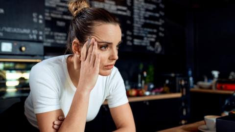 Coffee shop owner looking worried