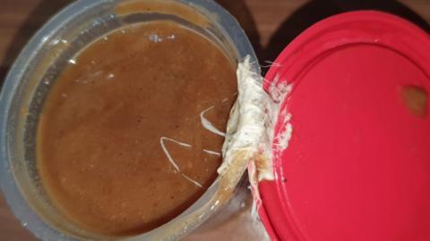 Gravy pot with sticky substance, possibly chewing gum
