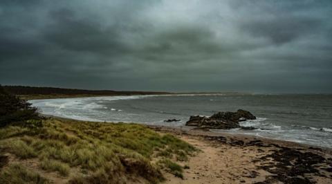 Cloudy & grey skies over a beach