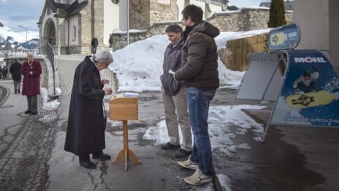 A woman votes in Obersaxen, Switzerland (12 Feb)