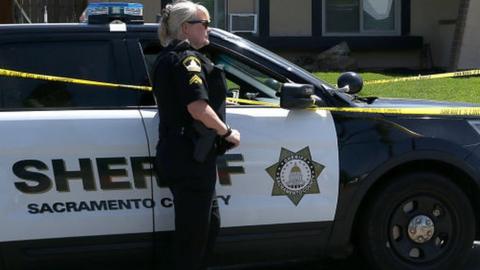 Police officer outside Sheriff car