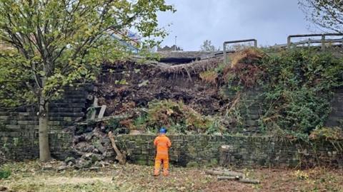 Collapsed wall alongside railway line