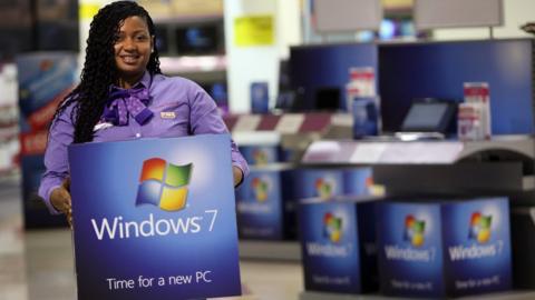 Someone holding a Windows 7 PC box.