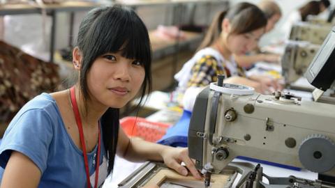 A worker uses a sewing machine at a handbag factory in China