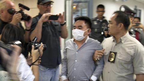 Bach Van Minh, also known as Boonchai Bach (C), a Vietnamese national who also holds Thai citizenship, is escorted by Thai police officers at the Suvarnabhumi airport's police station in Samut Prakan province, on the outskirts of Bangkok, Thailand