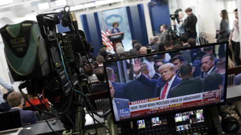 Trump on a TV screen during White House press briefing